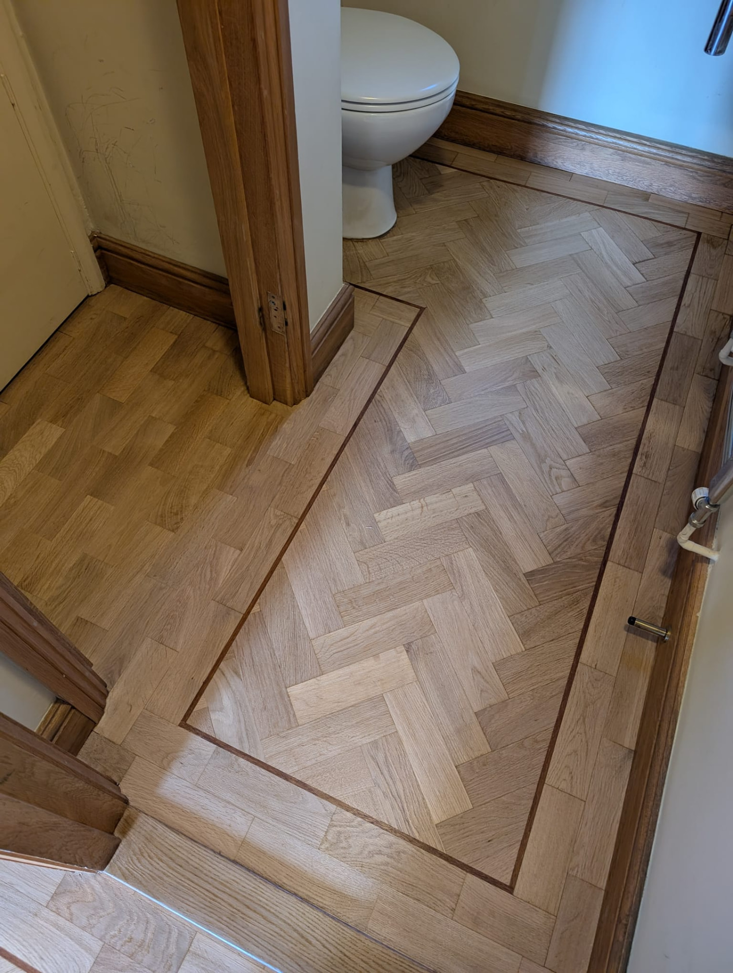 The same oak parquet cloakroom floor after sanding and refinishing